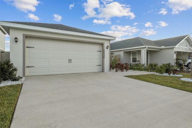 ranch-style home featuring a shingled roof, driveway, an attached garage, and stucco siding