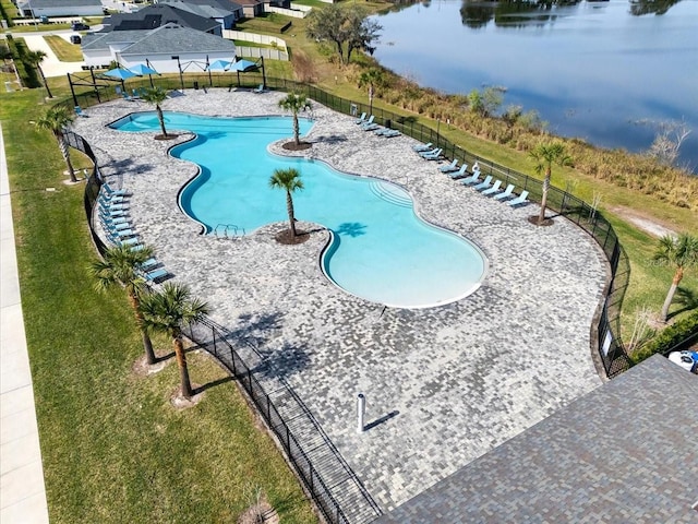 view of swimming pool with a yard and a water view