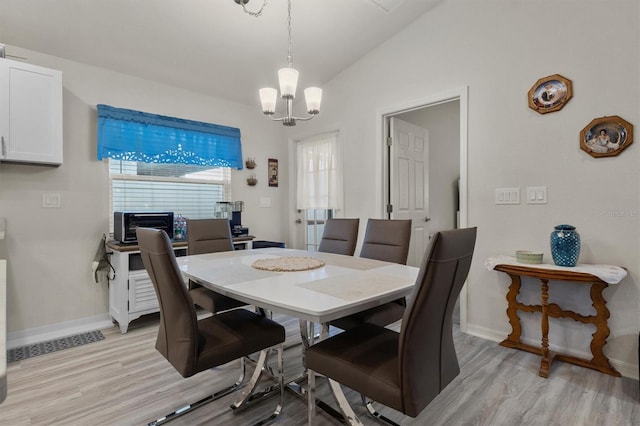 dining room featuring vaulted ceiling, baseboards, light wood-style flooring, and a healthy amount of sunlight