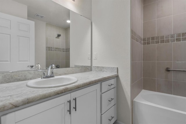 bathroom with visible vents, shower / bath combination, and vanity