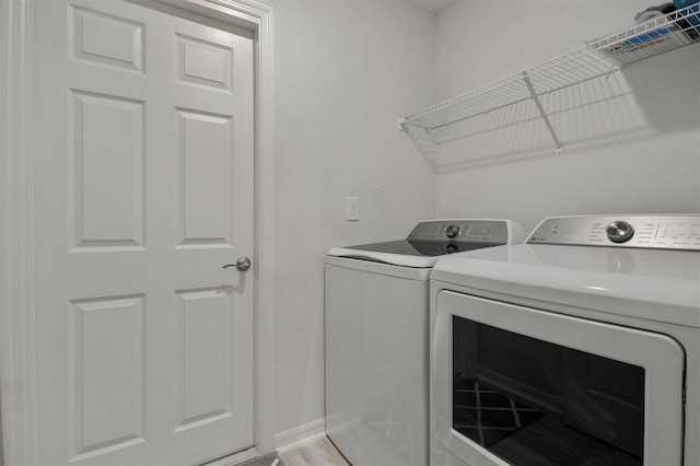 washroom with light wood-style floors, washer and dryer, and laundry area