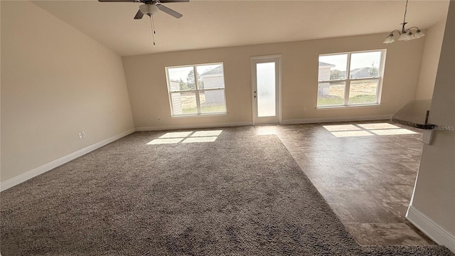 unfurnished room featuring vaulted ceiling, ceiling fan with notable chandelier, and baseboards