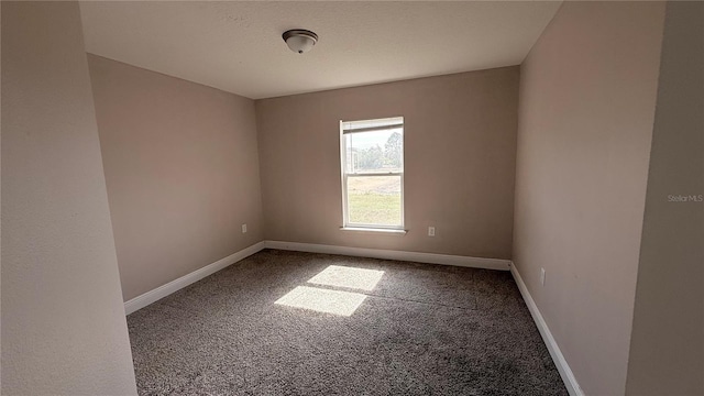 spare room featuring baseboards and carpet