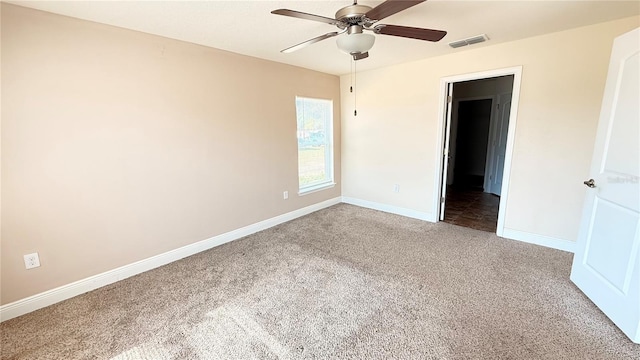 carpeted spare room featuring visible vents, baseboards, and ceiling fan