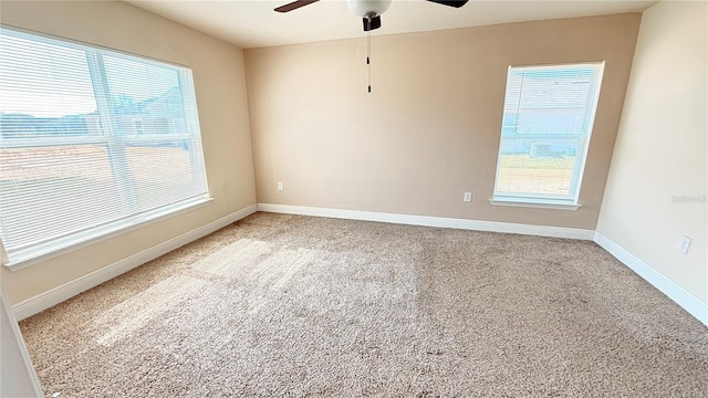 unfurnished room featuring light carpet, ceiling fan, and baseboards