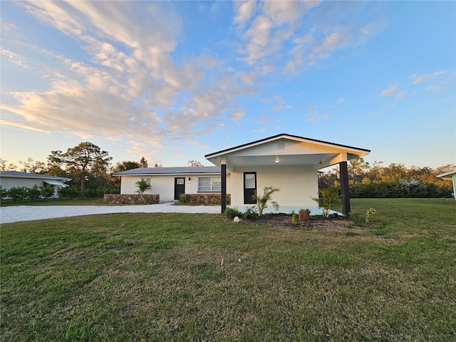 view of front facade with a yard and stucco siding