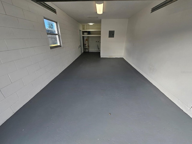 interior space featuring finished concrete flooring, concrete block wall, and electric panel