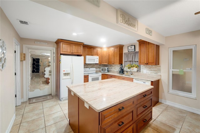 kitchen with sink, backsplash, white appliances, light stone counters, and light tile patterned floors