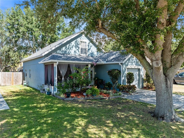 view of front facade featuring a garage, roof with shingles, fence, a front lawn, and stucco siding