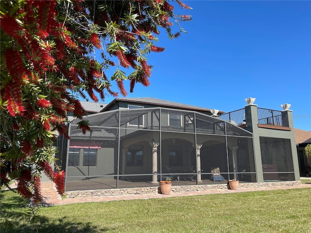 1820 Trophy Bass Way, Kissimmee, FL 34746 - back of house with stucco siding, a lawn, glass enclosure, roof with shingles, and a balcony