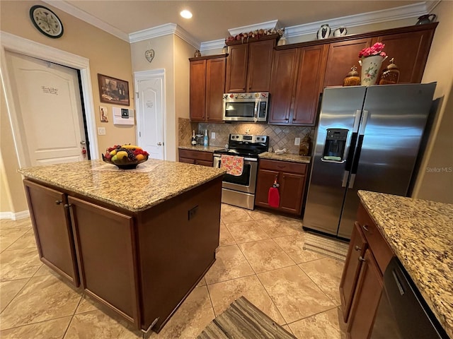 1820 Trophy Bass Way, Kissimmee, FL 34746 - kitchen with ornamental molding, light stone counters, a kitchen island, appliances with stainless steel finishes, and decorative backsplash