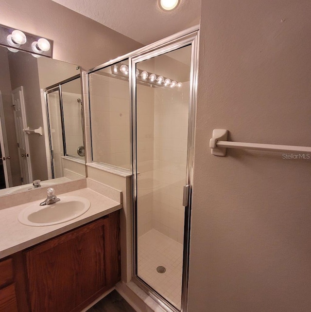 full bathroom with a shower stall and vanity