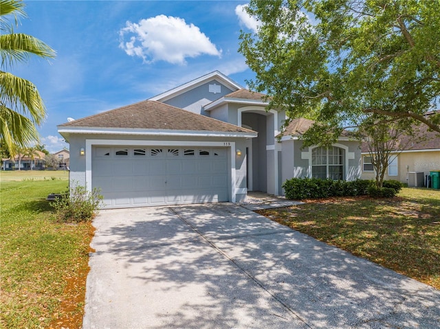 view of front of house with concrete driveway, stucco siding, central AC, a front lawn, and a garage