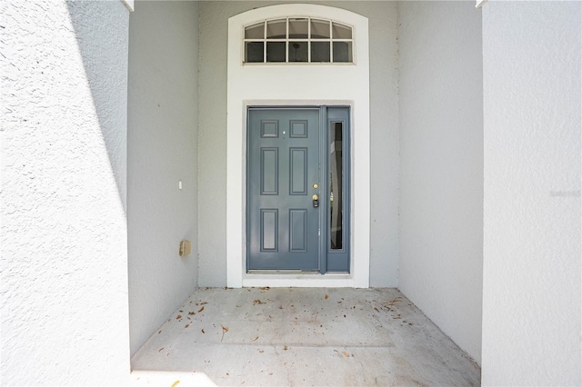 entrance to property featuring stucco siding