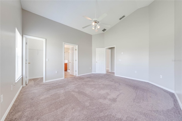 unfurnished bedroom featuring light colored carpet, visible vents, baseboards, and a spacious closet