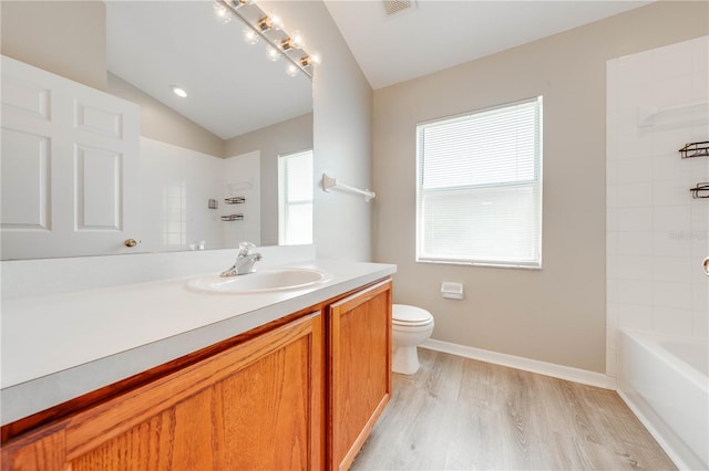 bathroom with baseboards, wood finished floors, toilet, vanity, and lofted ceiling