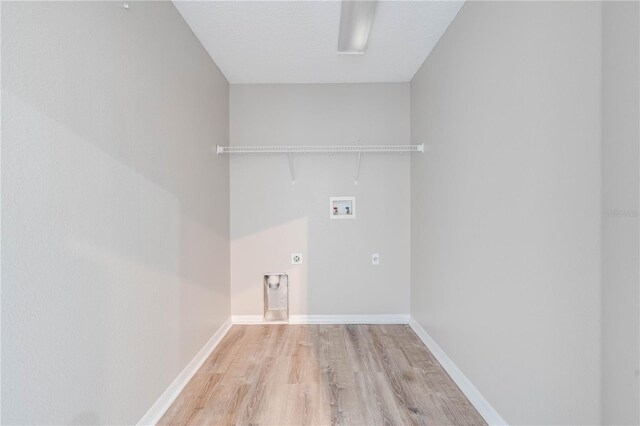 washroom with hookup for a washing machine, baseboards, light wood-style flooring, electric dryer hookup, and laundry area