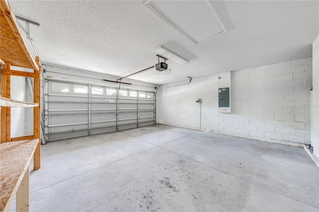 garage with electric panel, a garage door opener, and concrete block wall