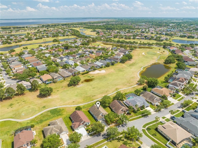 aerial view with golf course view, a water view, and a residential view