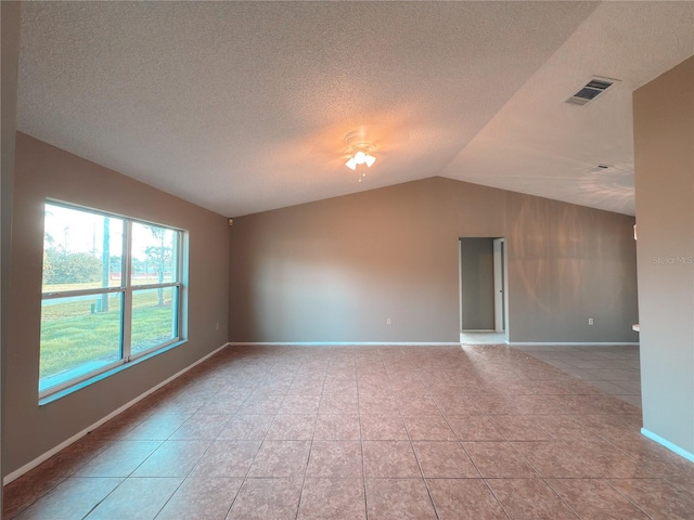 unfurnished room featuring light tile patterned floors, a textured ceiling, and lofted ceiling