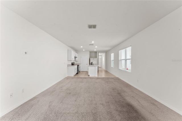 unfurnished living room with light carpet