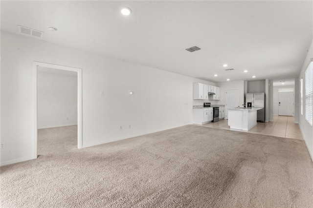 unfurnished living room featuring light colored carpet