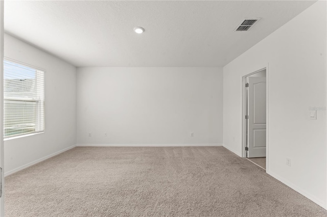 unfurnished room featuring light colored carpet