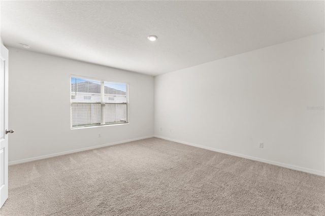 carpeted spare room with a textured ceiling