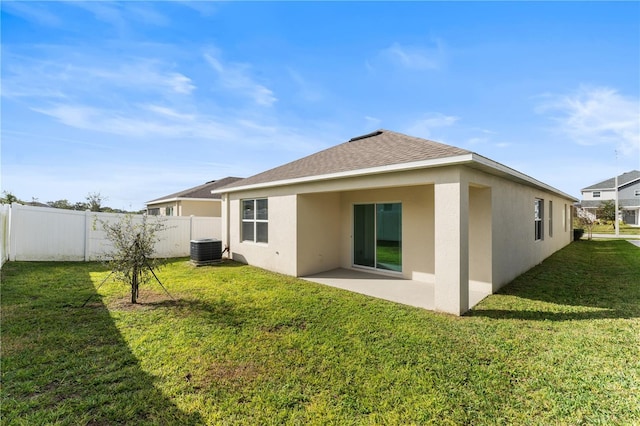 rear view of house with cooling unit, a lawn, and a patio area