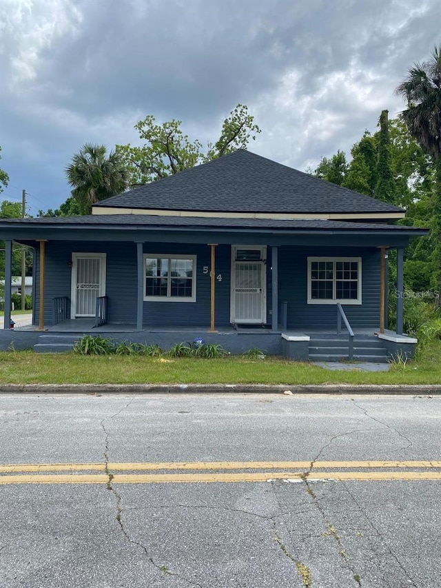 view of front of home with covered porch and a shingled roof