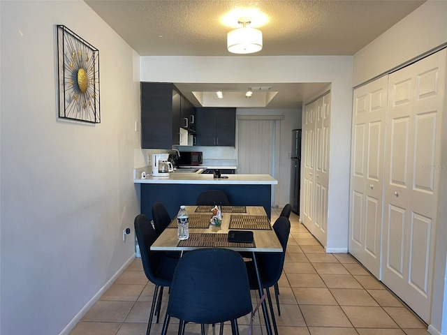 dining area with light tile patterned floors and a textured ceiling