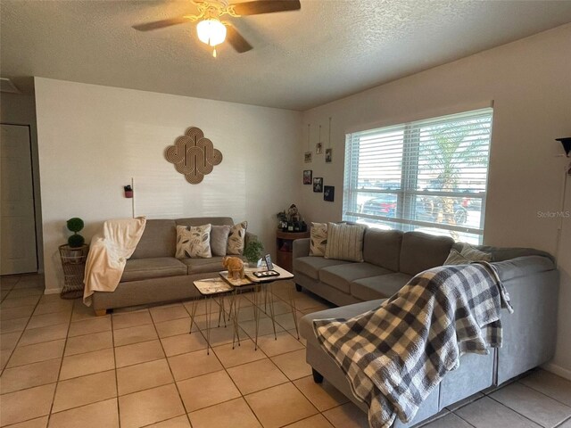 living room featuring ceiling fan, a textured ceiling, and light tile patterned floors