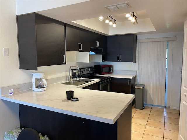 kitchen featuring sink, stainless steel range with electric cooktop, light tile patterned floors, kitchen peninsula, and a raised ceiling