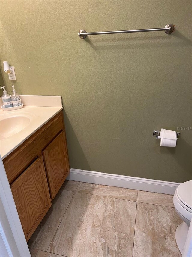 350 Corsica Ct, Kissimmee, FL 34758 - bathroom featuring toilet, vanity, and baseboards