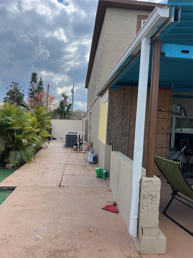 350 Corsica Ct, Kissimmee, FL 34758 - view of home's exterior with central AC unit, fence, a patio, and stucco siding