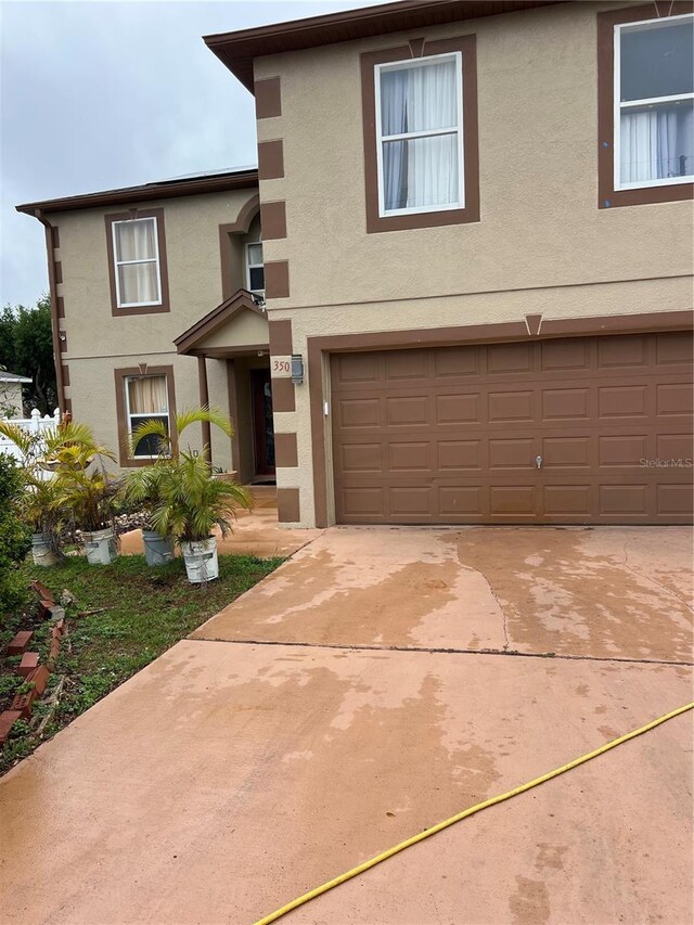350 Corsica Ct, Kissimmee, FL 34758 - view of front of house featuring a garage, stucco siding, and concrete driveway