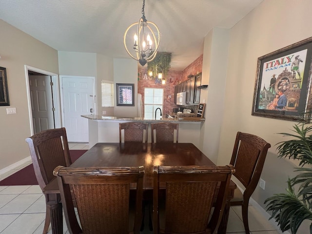 tiled dining room with a notable chandelier and sink