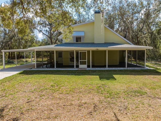 back of house featuring a lawn and a sunroom