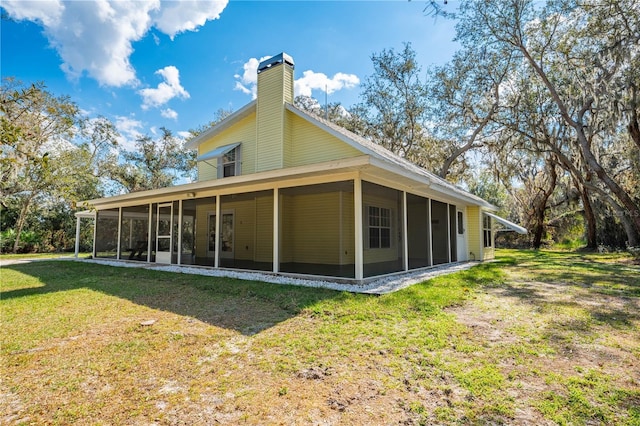 back of house featuring a yard and a sunroom