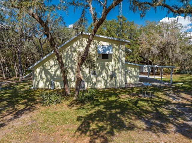 view of home's exterior featuring a carport and a lawn