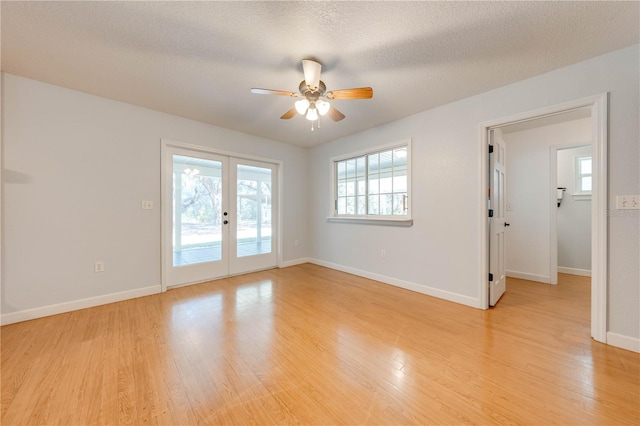 unfurnished room featuring french doors, ceiling fan, light hardwood / wood-style floors, and a textured ceiling