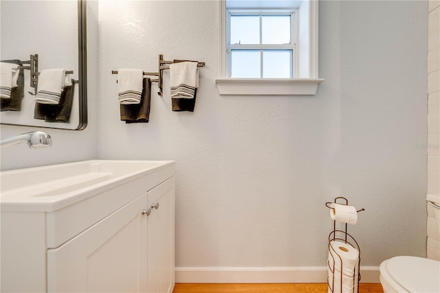 bathroom with vanity, hardwood / wood-style floors, and toilet