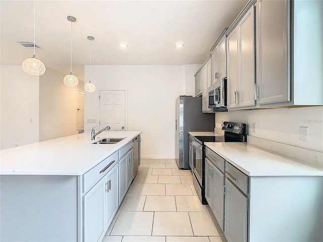 kitchen featuring pendant lighting, stainless steel appliances, a kitchen island with sink, and sink