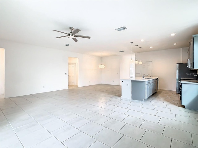 kitchen featuring hanging light fixtures, sink, light tile patterned floors, and ceiling fan