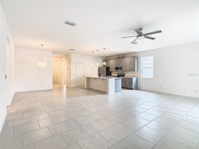 unfurnished living room with ceiling fan and light tile patterned flooring