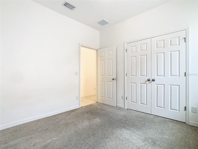 unfurnished bedroom with light carpet and a closet