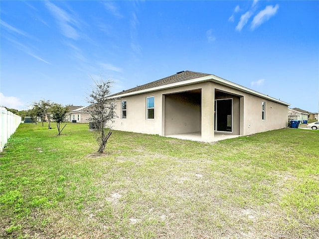 rear view of house featuring a patio and a yard