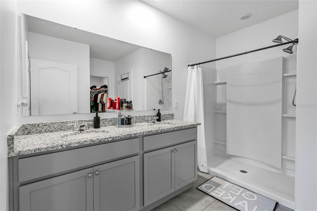 bathroom featuring tile patterned flooring, vanity, and walk in shower