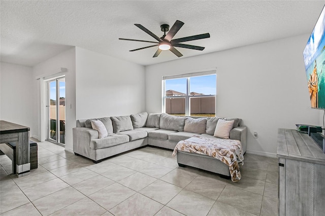 living room with light tile patterned floors, a textured ceiling, and ceiling fan