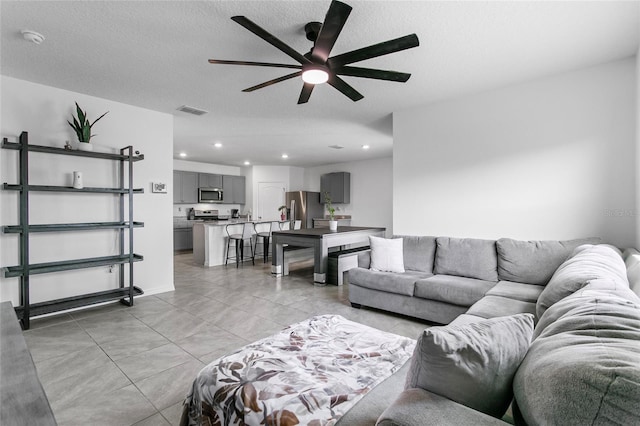 living room featuring a textured ceiling and ceiling fan